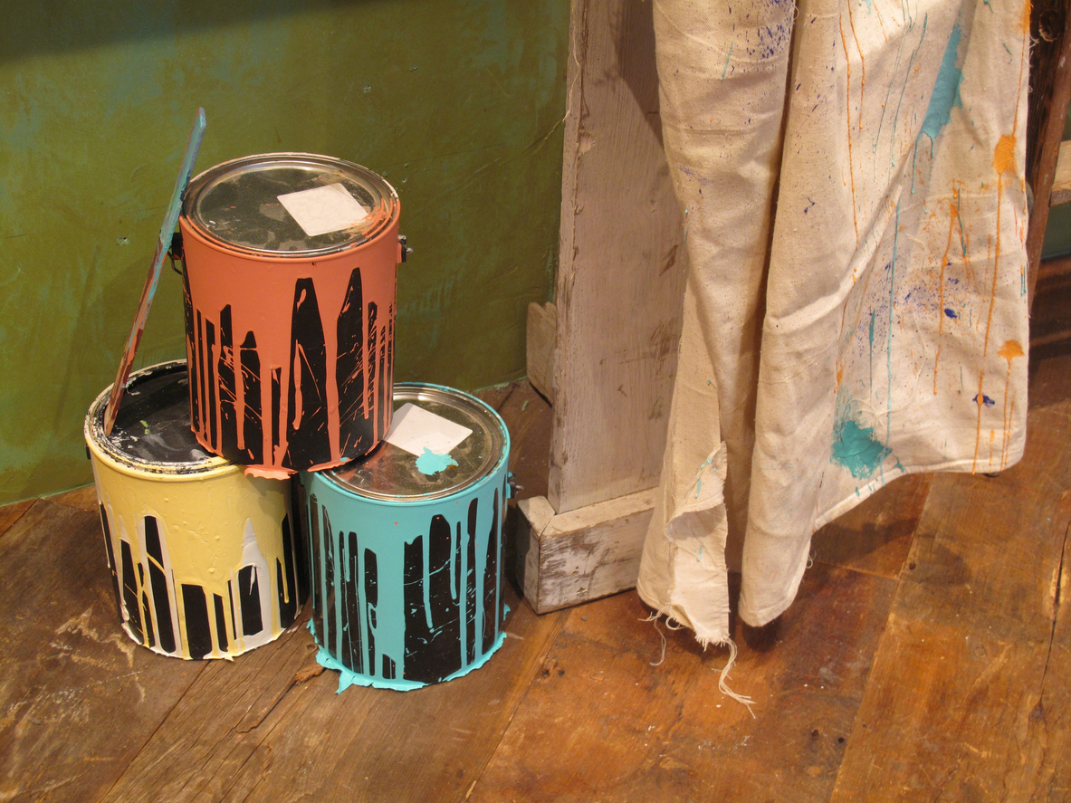 Three paint cans and a drop cloth