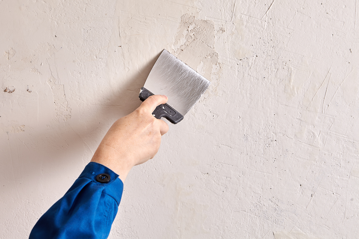 Repairing a plaster wall at a Walnut Creek, CA home with putty and work tools 